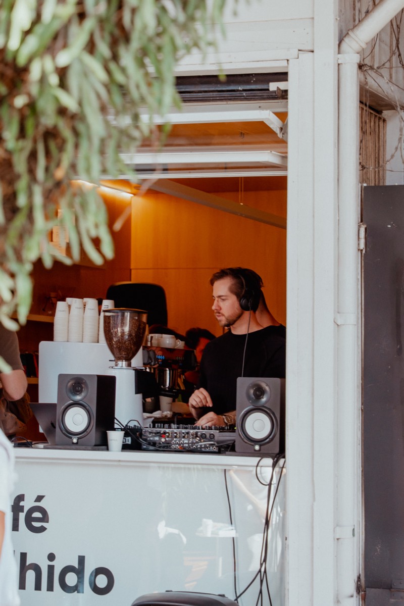 DJ tocando atrás da máquina de espresso